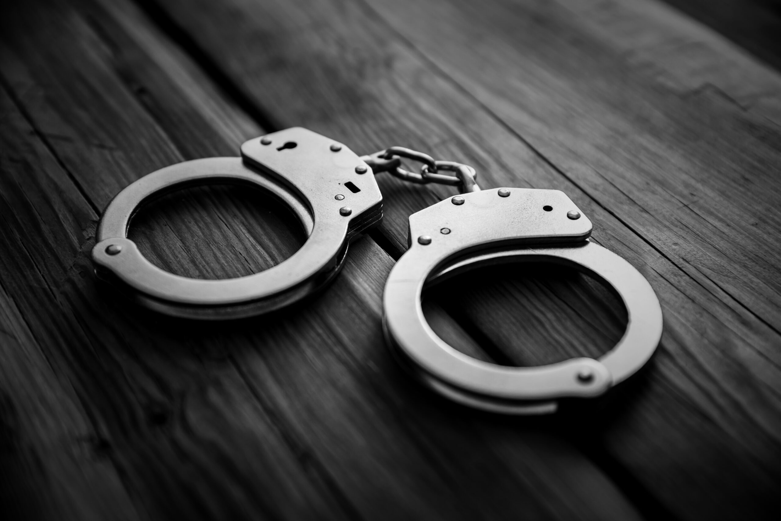 Handcuffs on wooden table background